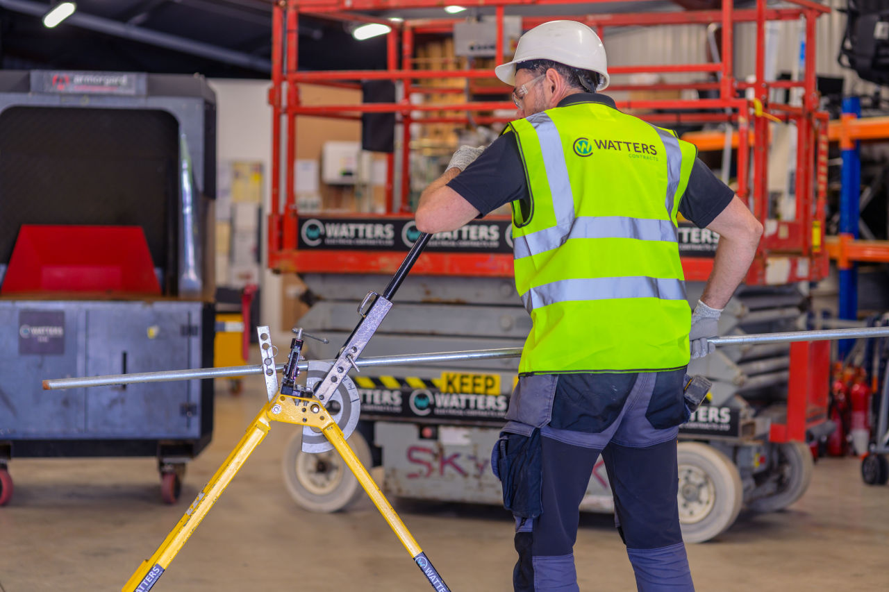 Electrician bending conduit in the workshop